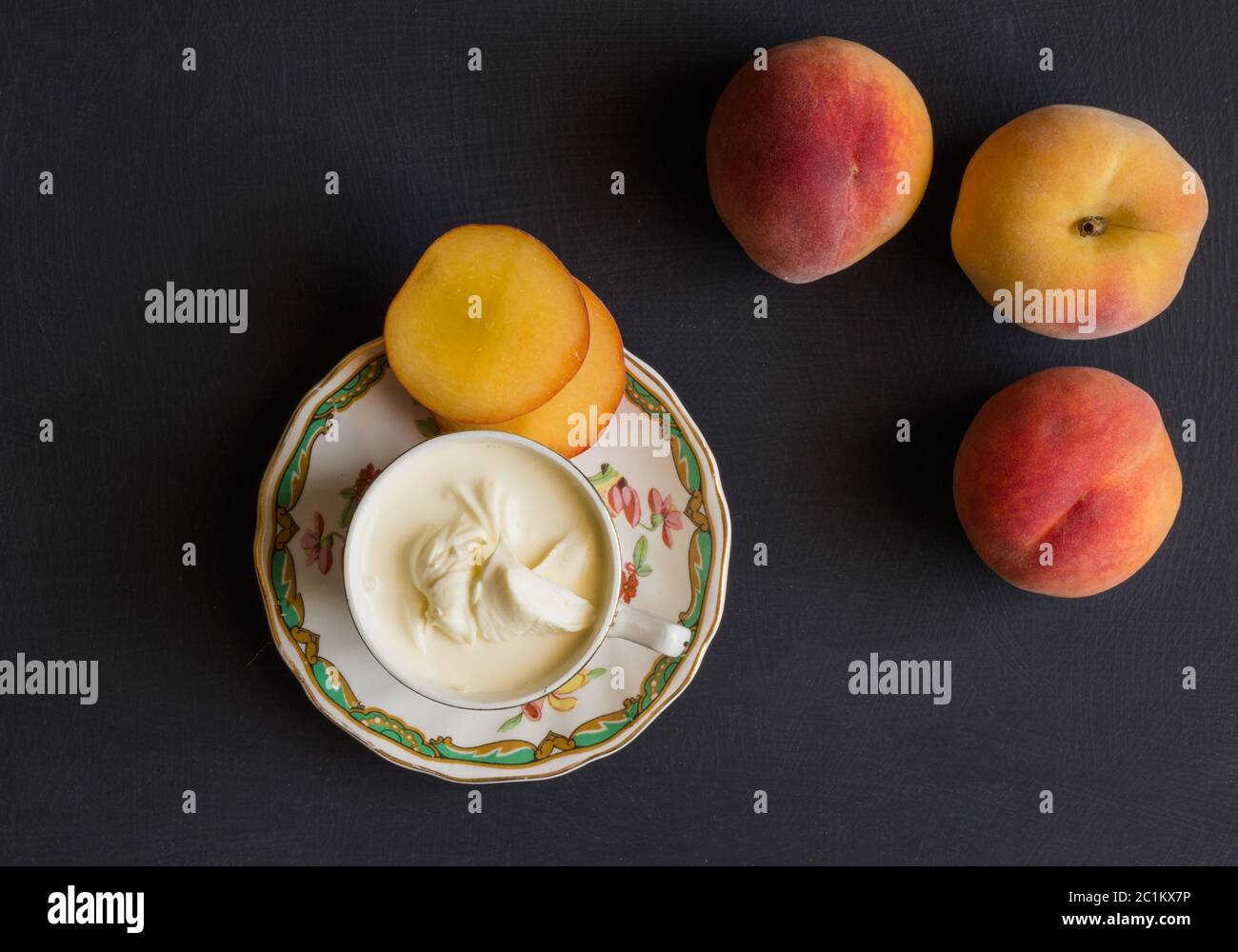 Pêches et crème sur fond noir - vue du dessus de la photo Banque D'Images