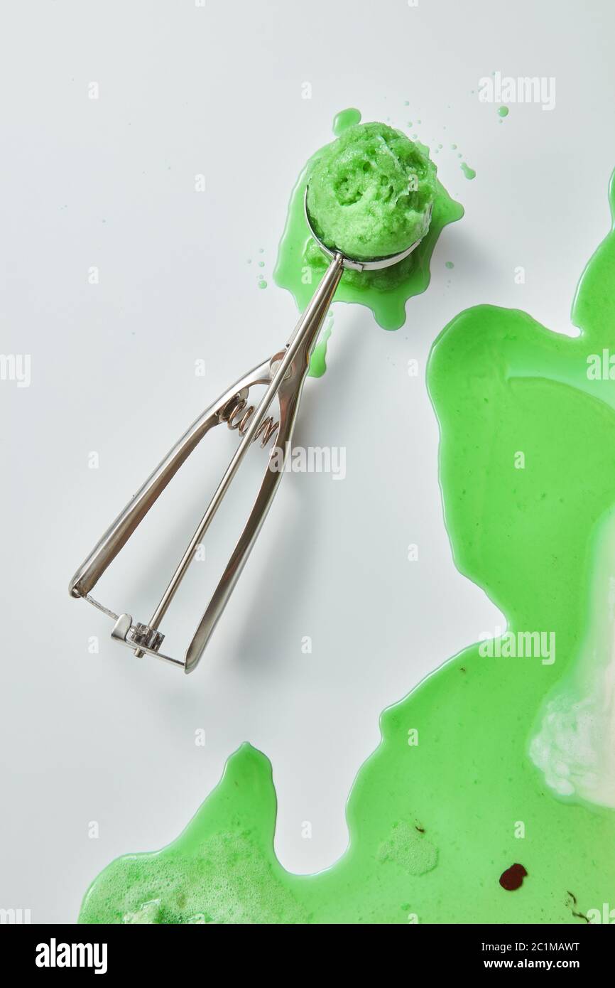 La glace fondante. Sur fond gris, une pelle avec de la crème glacée avec des gouttes et du vsplaska. Copier l'espace. Vue de dessus Banque D'Images