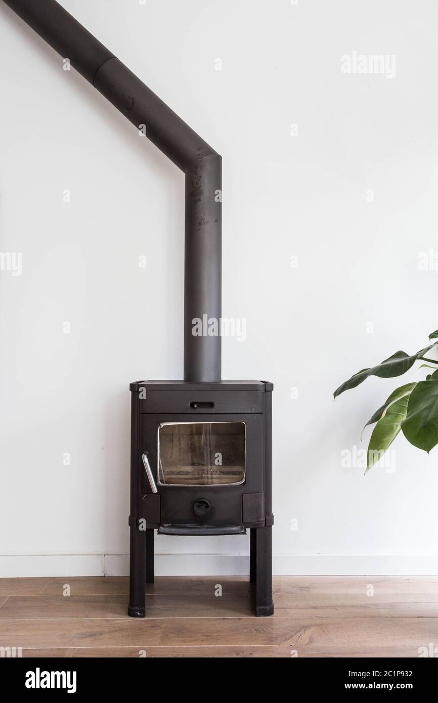 Cheminée en fer comme une cuisinière dans une maison avec le feu intérieur scandinave, design moderne, salle blanche Banque D'Images