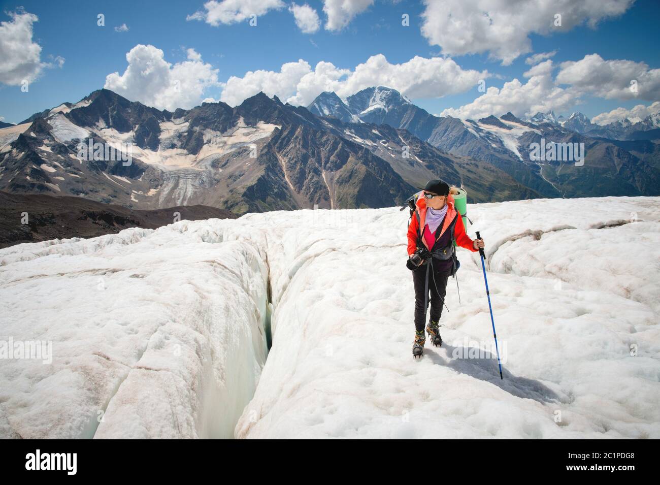 Femme alpiniste appréciant la beauté du glacier marche sur le glacier dans le crampon et les lunettes de soleil. Sur fond o Banque D'Images