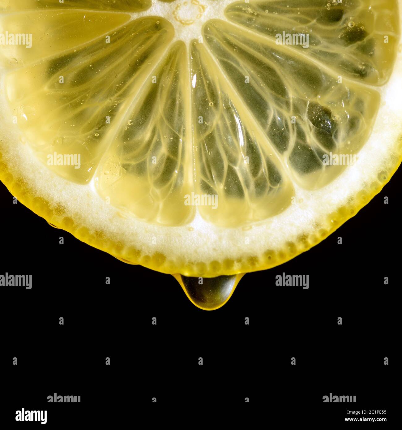 tranche de citron avec une goutte de jus sur un fond noir gros plan Banque D'Images