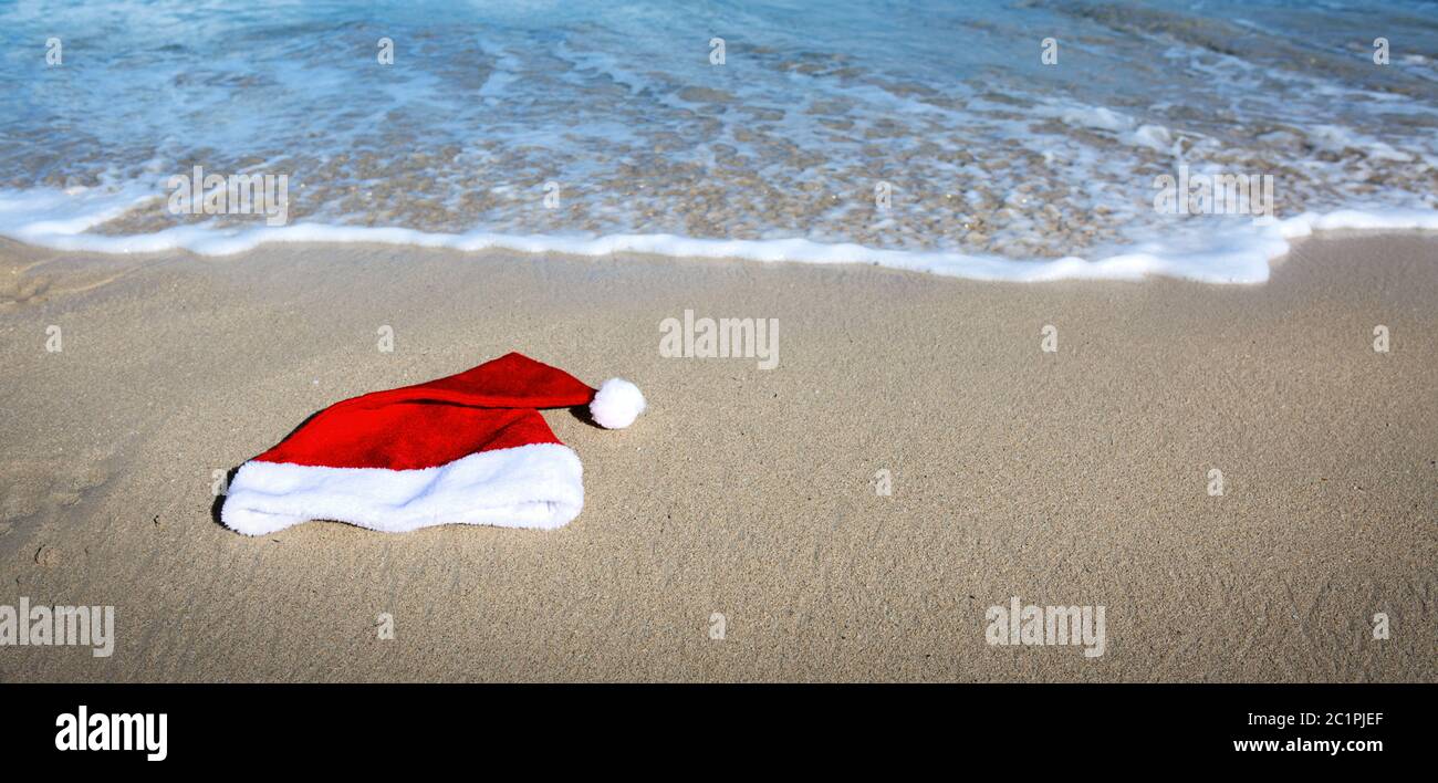 Chapeau du Père Noël sur la plage des caraïbes. Arrière-plan de Noël Banque D'Images