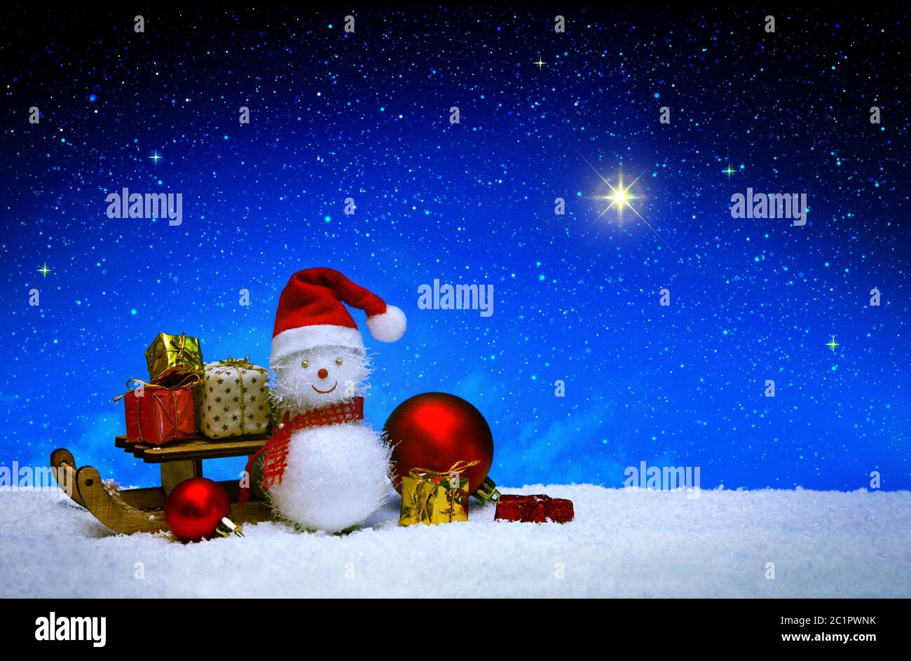 Bonhomme de neige de Noël avec chapeau de père noël isolé sur fond ciel étoilé. Banque D'Images