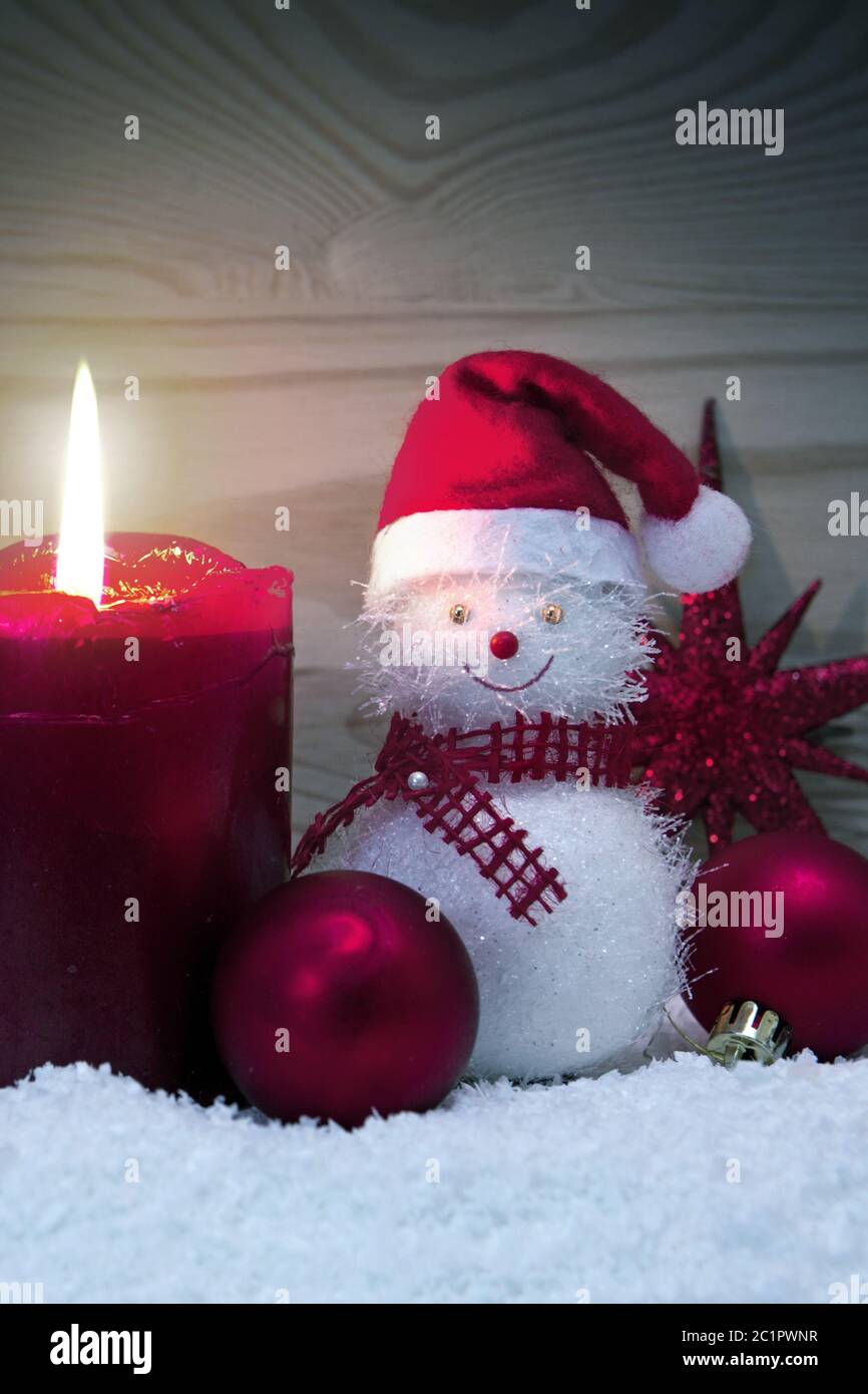 Bougie de l'AVENT et bonhomme de neige avec décoration de Noël rouge isolée. Banque D'Images