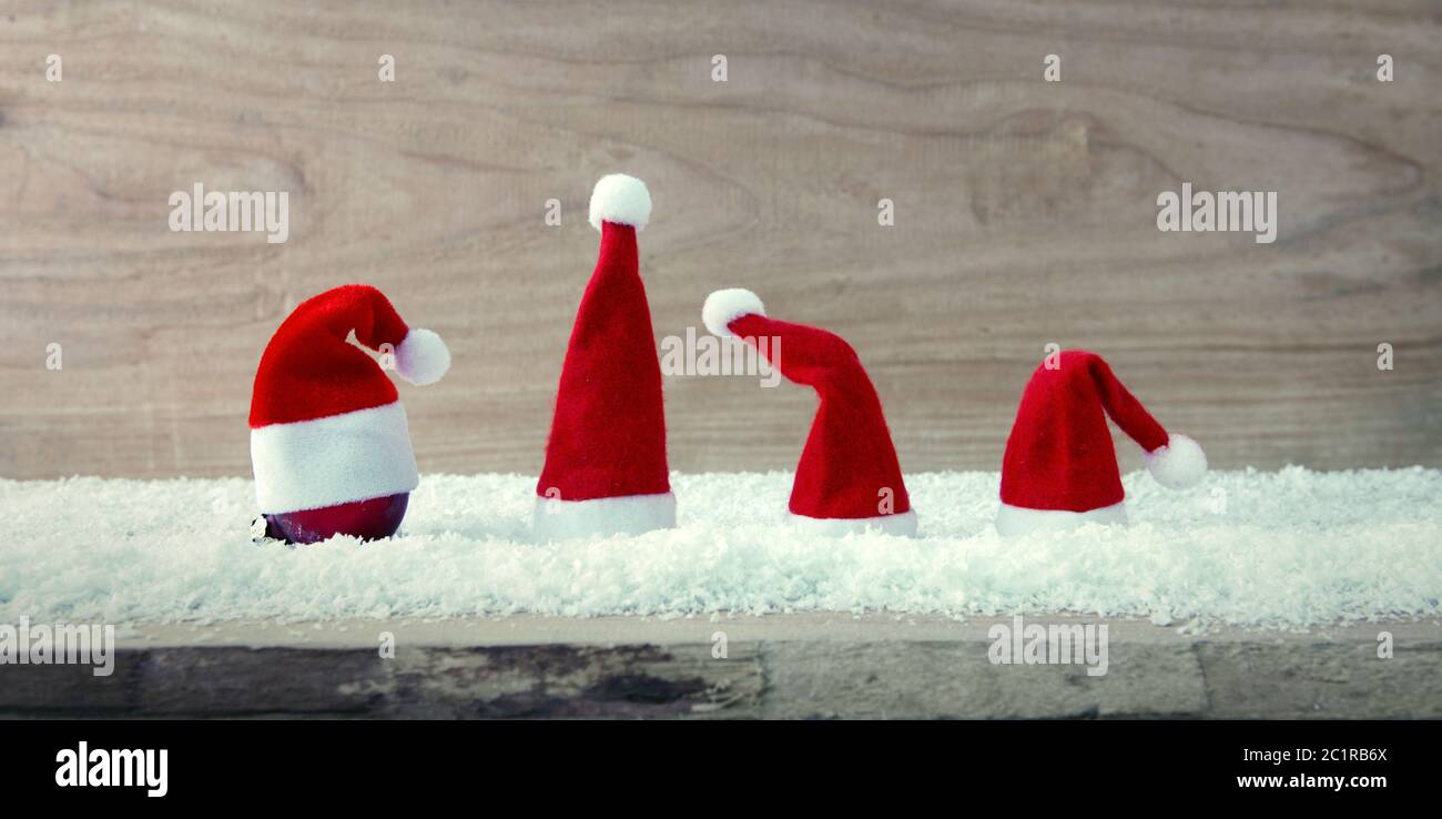 Quatre chapeaux rouges du Père Noël et neige blanche . Banque D'Images