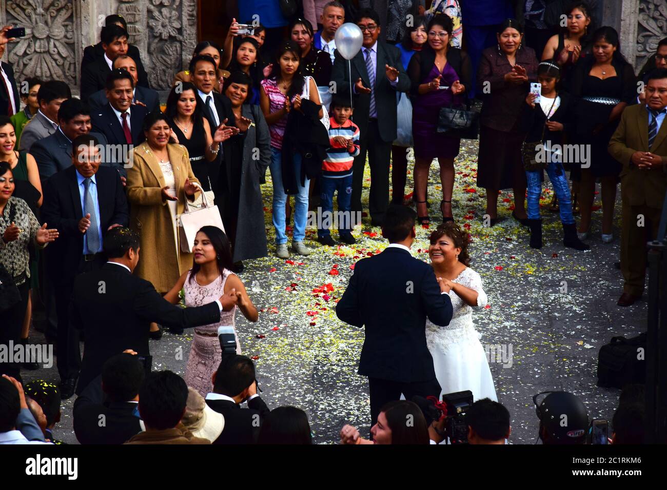 Mariage péruvien avec mariée et danse au balai à l'extérieur de l'église. Banque D'Images