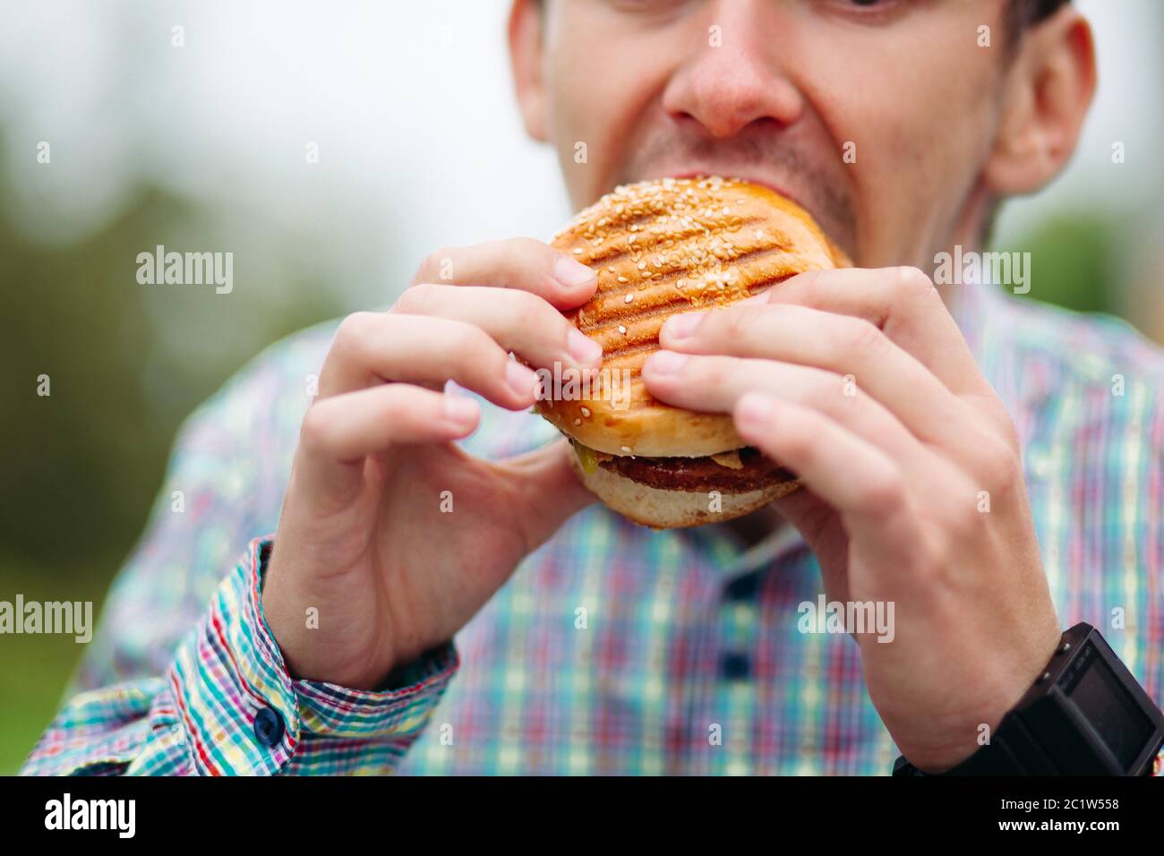 Close-up of man biting hamburger. Banque D'Images