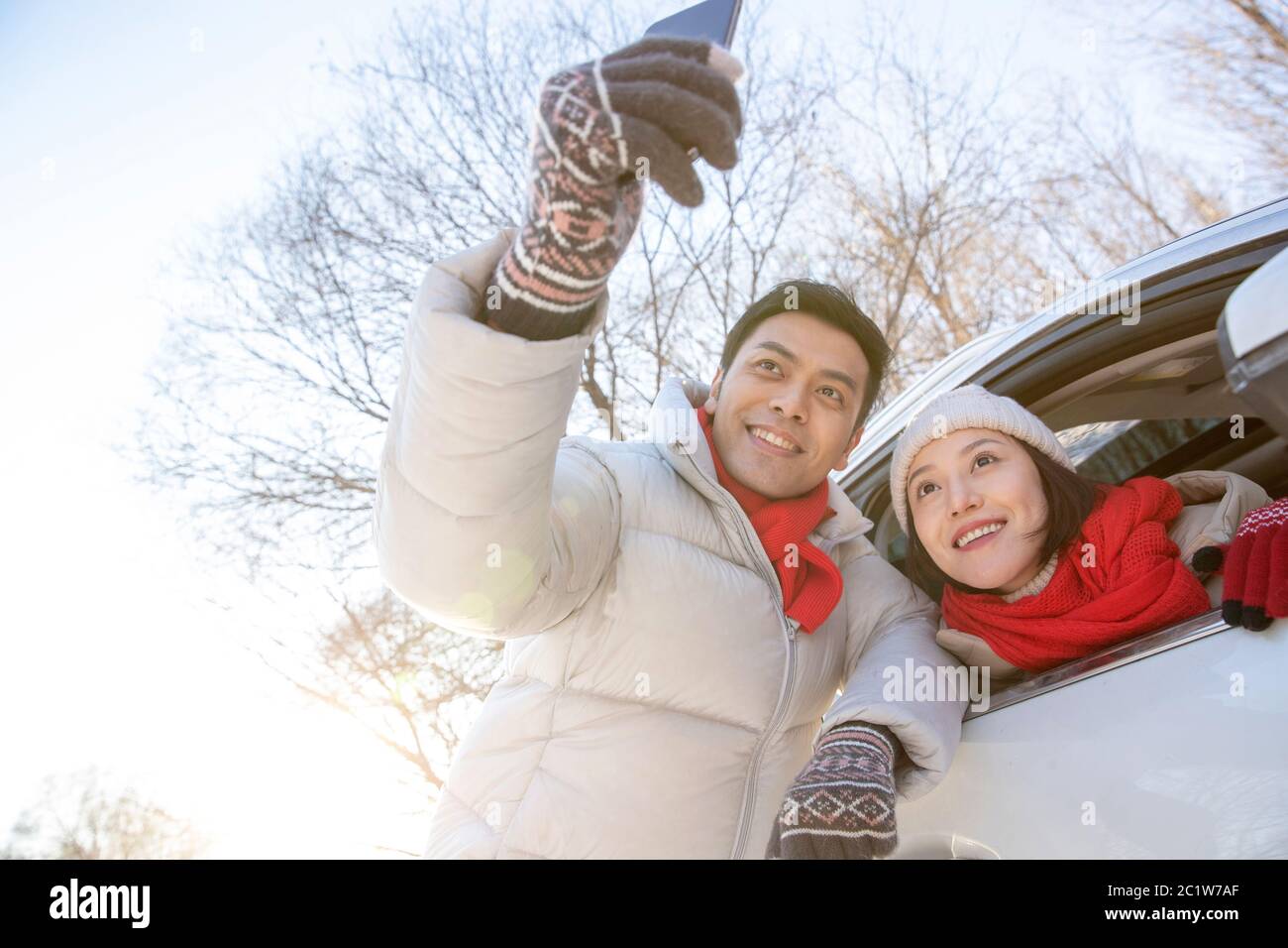 Le jeune couple à côté du téléphone de voiture Banque D'Images