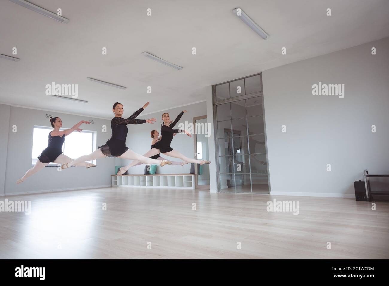 Des danseuses de ballet caucasiennes attirantes en costumes noirs s'exerçant pendant une classe de ballet Banque D'Images