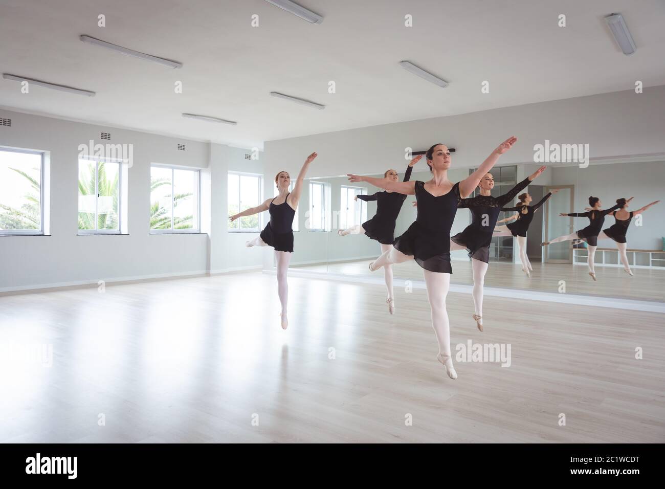 Des danseuses de ballet caucasiennes attirantes en costumes noirs s'exerçant pendant une classe de ballet Banque D'Images