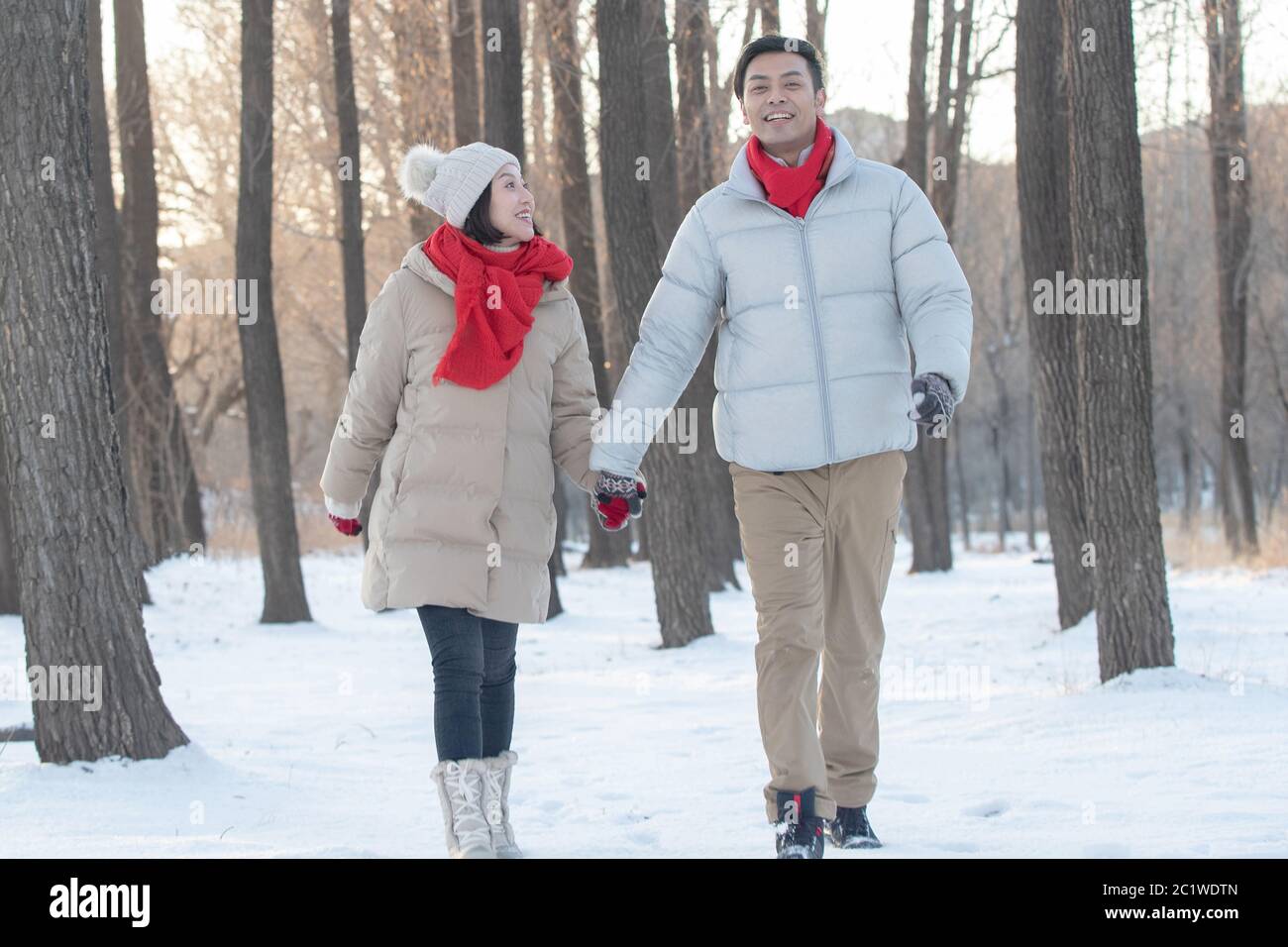 Le jeune couple marchant sur la neige Banque D'Images