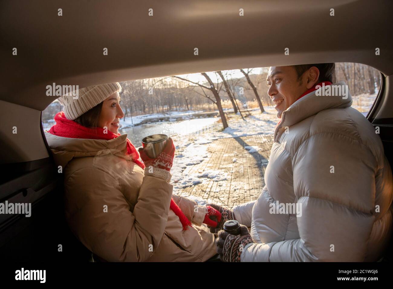 Assis dans la voiture à côté des jeunes couples Banque D'Images