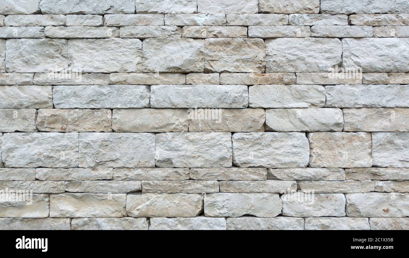 Mur gris en pierre sèche de grosses pierres naturelles rectangulaires en gros plan Banque D'Images
