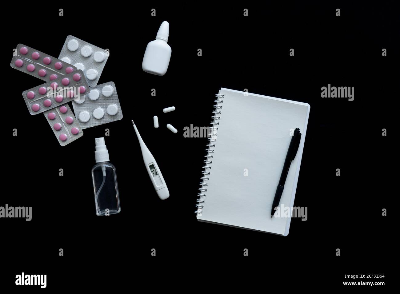 vue de dessus du thermomètre, des pilules et du carnet sur fond noir Banque D'Images
