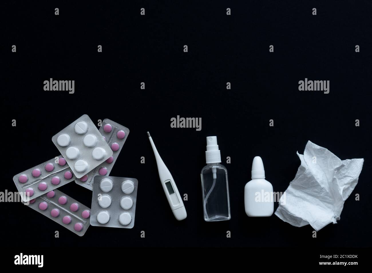 vue de dessus des pilules, du thermomètre et du vaporisateur nasal sur fond noir Banque D'Images
