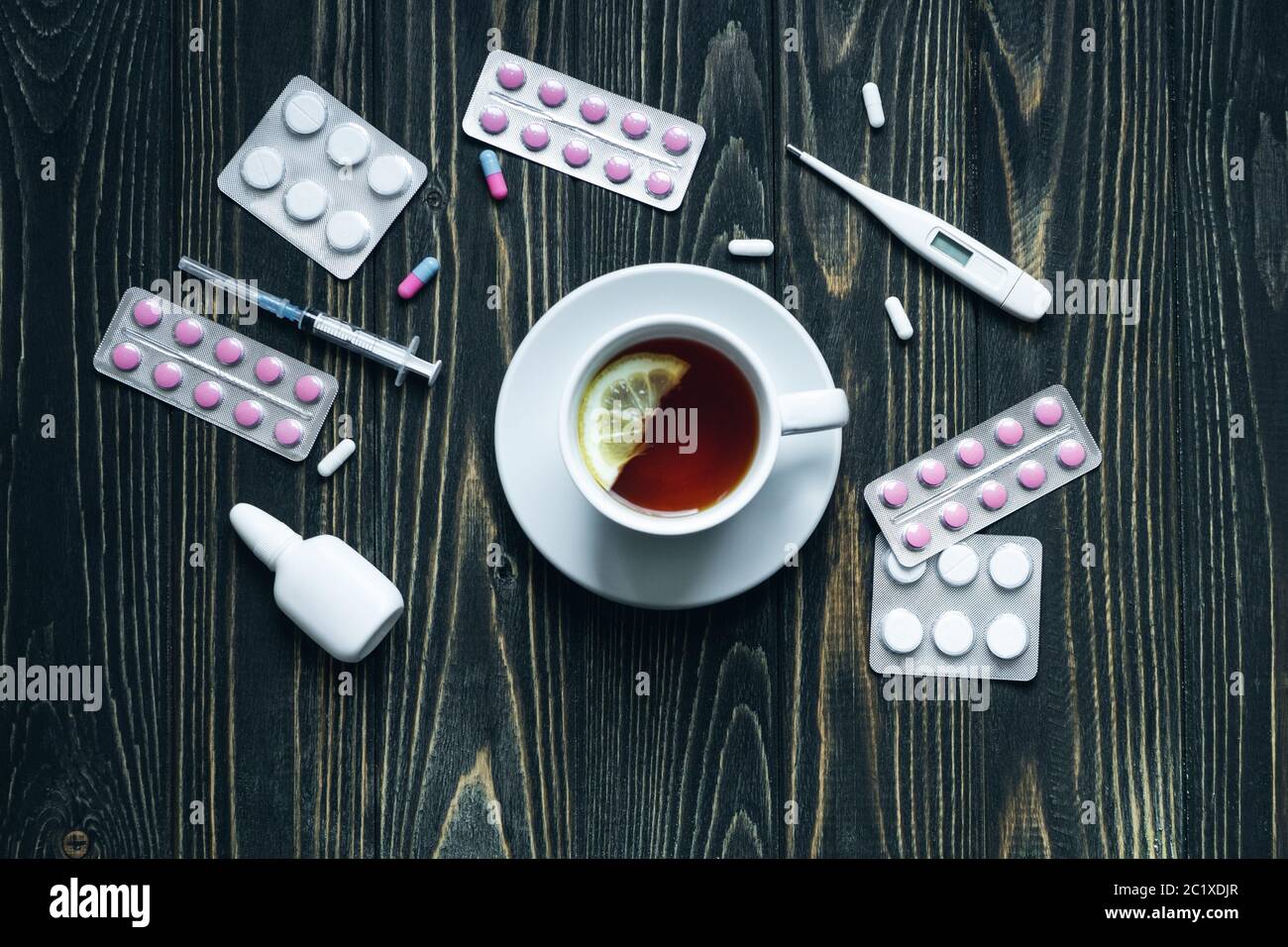 vue de dessus d'une tasse de thé, de pilules et de thermomètre sur fond de bois. Banque D'Images