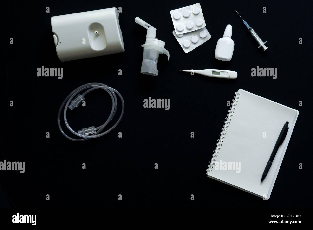 vue de dessus du nébuliseur, des pilules, du thermomètre et du carnet sur fond noir Banque D'Images
