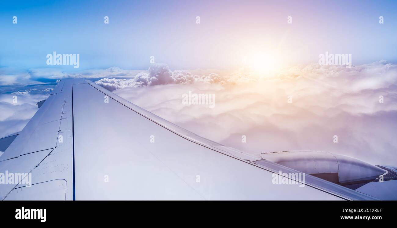 Aile d'avion au-dessus des nuages au lever du soleil. Banque D'Images Aile d'avion au-dessus des nuages au lever du soleil. Banque D'Images