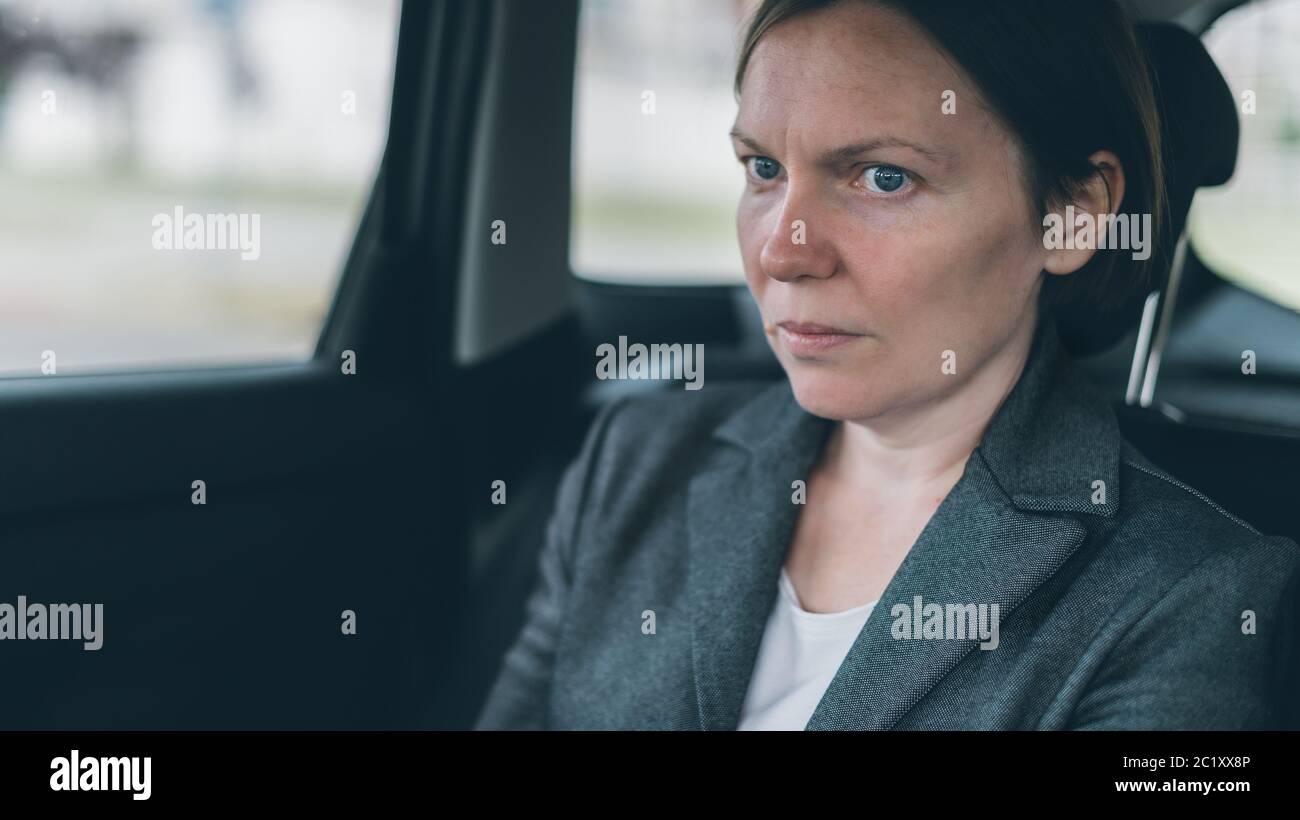 Femme d'affaires inquiète assise sur le siège de dossier de voiture, regardant nerveux et anxieux Banque D'Images