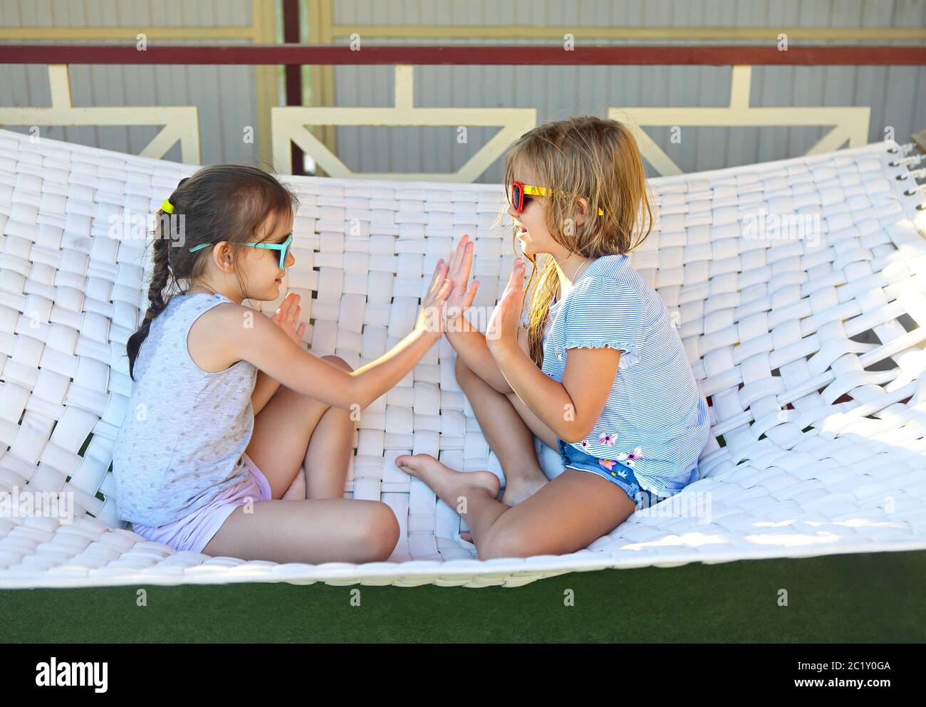 Petites filles heureuses jouant sur un hamac en été Banque D'Images