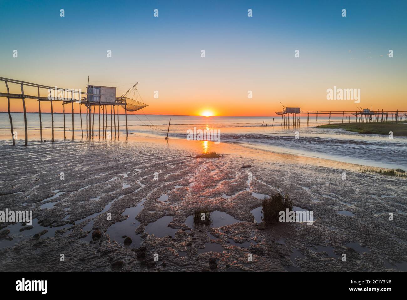 Coucher de soleil sur la plage avec des cabanes de pêche traditionnelles sur les rives de l'estuaire de la Gironde en été sur la côte ouest de l'Atlantique, Charente Maritime, France Banque D'Images