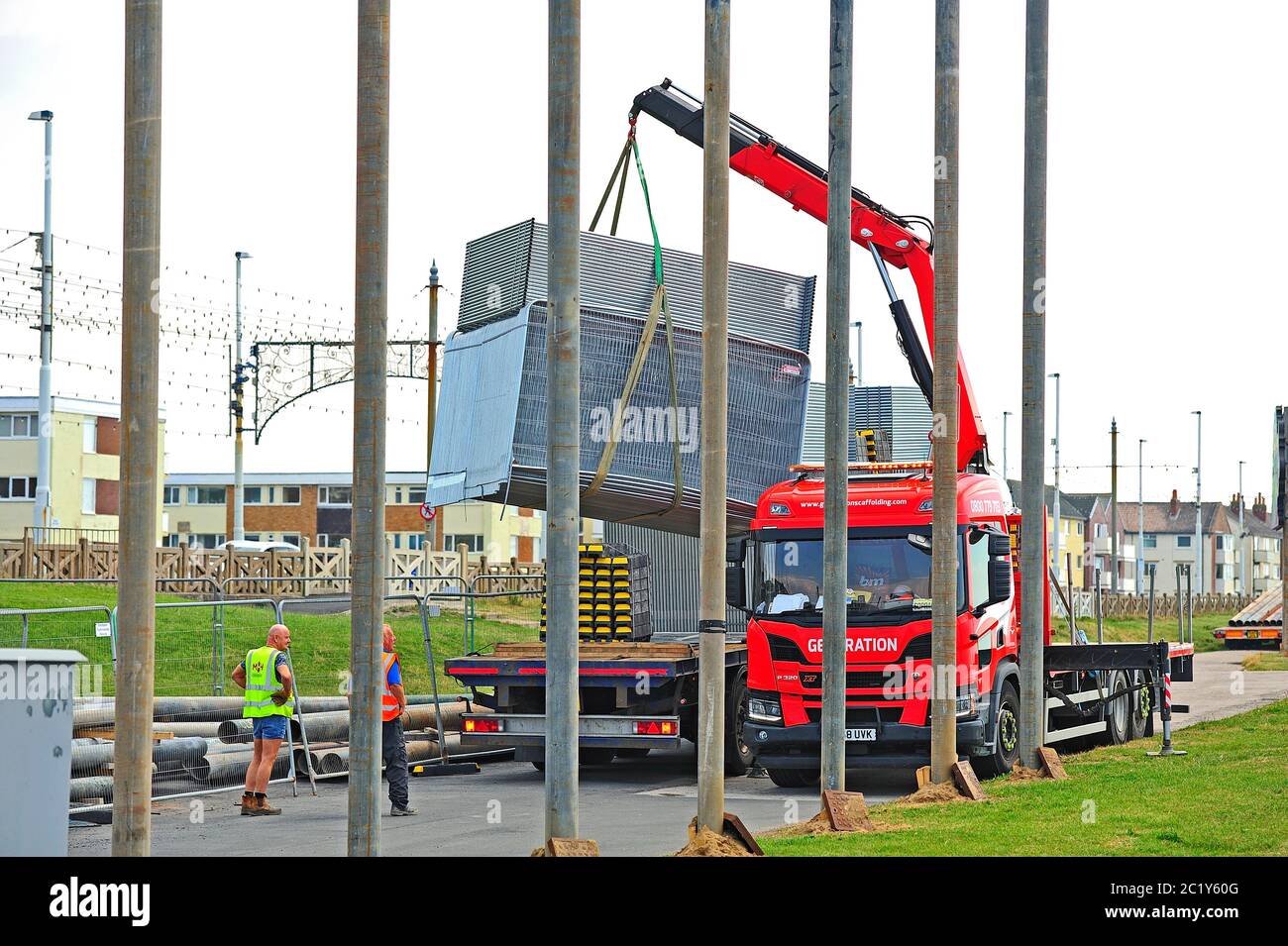 Deux ouvriers déchargent des clôtures d'un camion en préparation à l'illumination de Blackpool tableaux à ériger sur la promenade de Bispham Banque D'Images