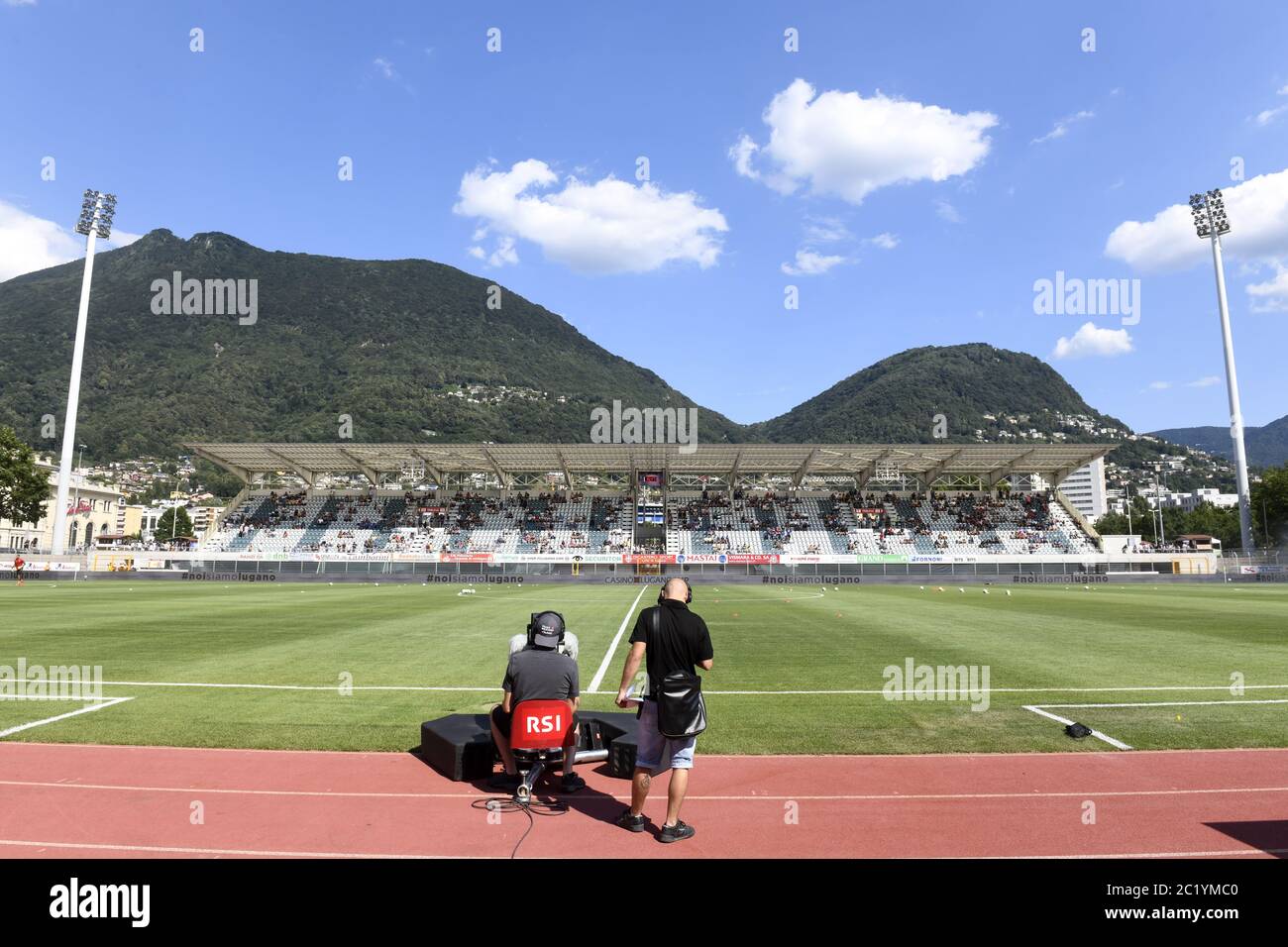 En plein air, le caméraman suisse RSI se trouve sur le terrain vert du stade de Cornaredo, avec les montagnes vertes en arrière-plan, à Lugano. Banque D'Images