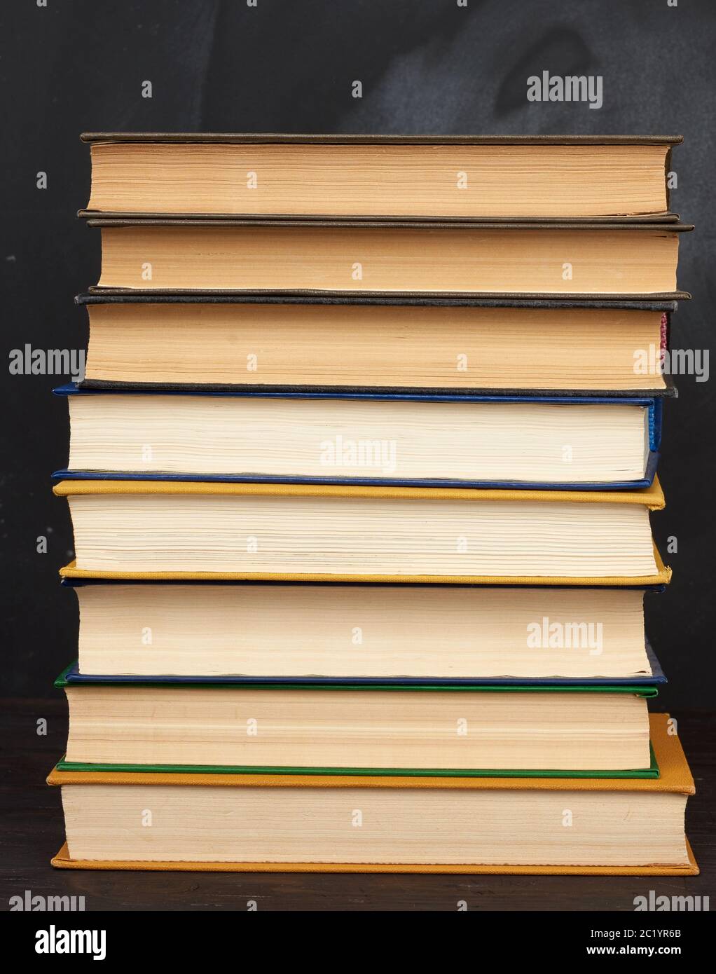 pile de divers livres de hardback sur le fond d'un tableau noir vide de craie, de retour à l'école Banque D'Images