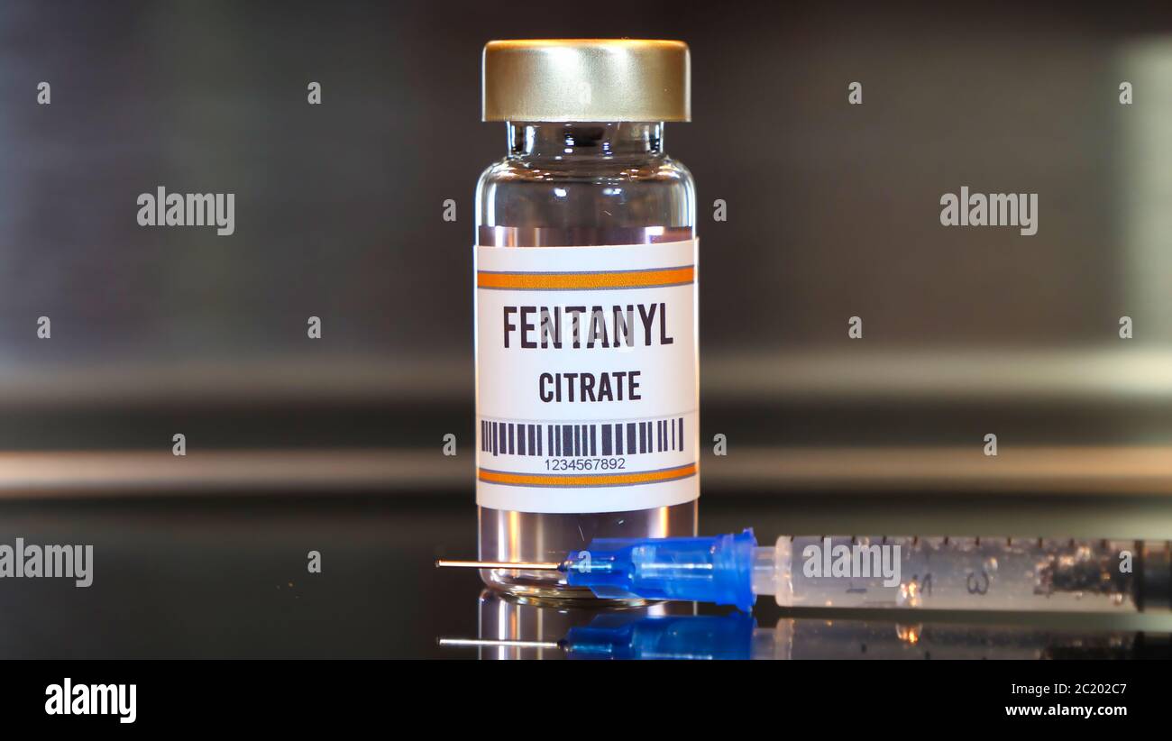 Médicament et seringue fentanyl sur table noire avec réflexions et fond inoxydable. Banque D'Images