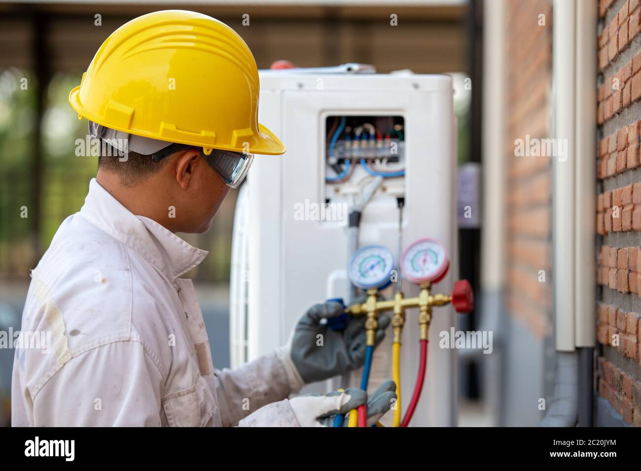 Le technicien de climatisation vérifie le compresseur avec la jauge Banque D'Images