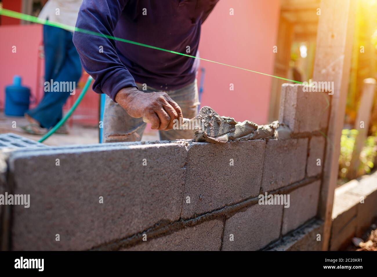 Techniques de maçonnerie en ciment pour la construction de clôtures de construction Banque D'Images