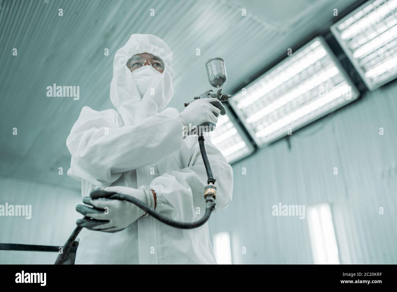 Aérographe peinture homme porter un chiffon et un masque uniforme prêt à travailler dans le garage de peinture de couleur Banque D'Images