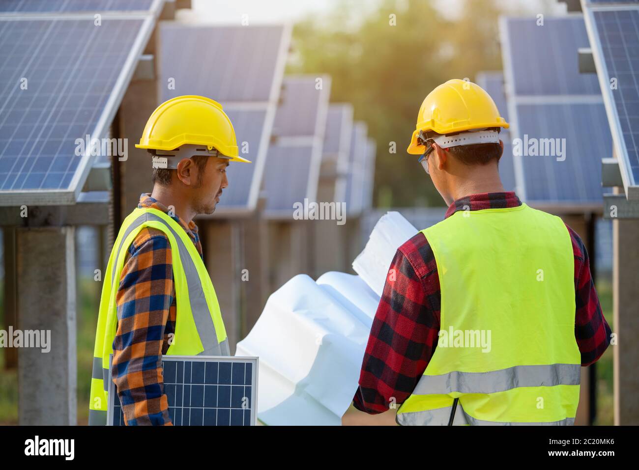 L'équipe d'ingénierie électrique travaille dans une ferme de panneaux solaires ou dans la réparation de panneaux photovoltaïques Banque D'Images