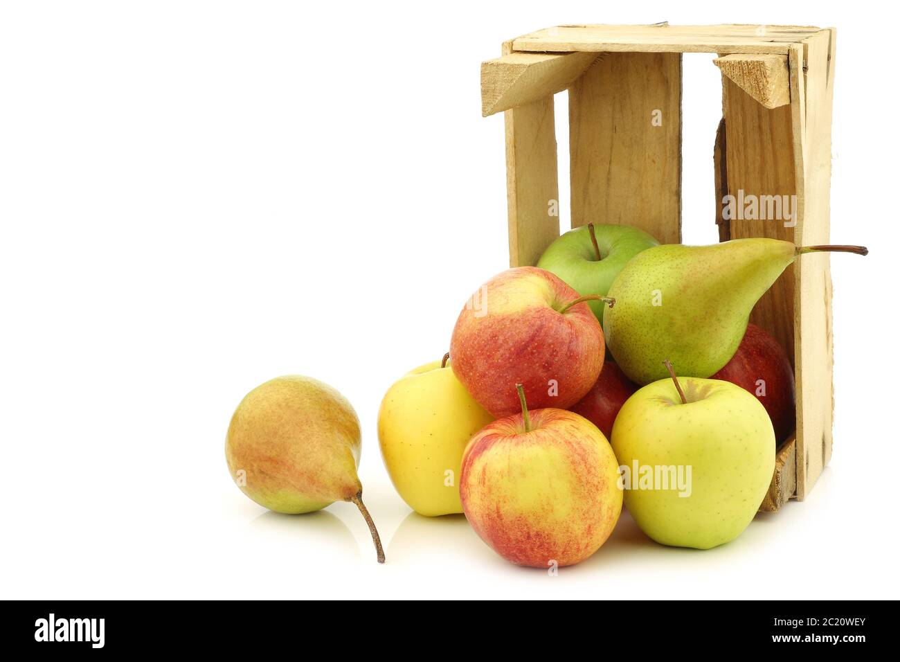 Poires et pommes fraîchement récoltées dans une caisse en bois sur fond blanc Banque D'Images