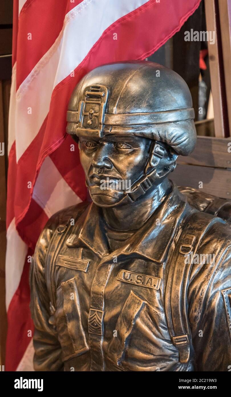 Statue extérieure et porte-drapeau d'un militaire américain en pierre moulée avec finition bronze à vendre dans un restaurant et magasin Cracker Barrel Banque D'Images
