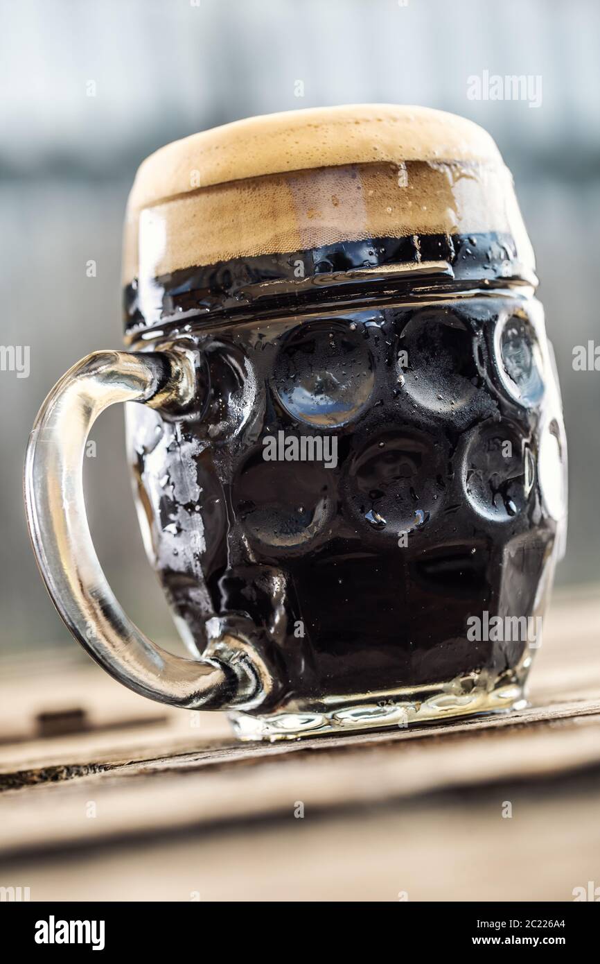 Une tasse de bière foncée avec mousse Banque D'Images