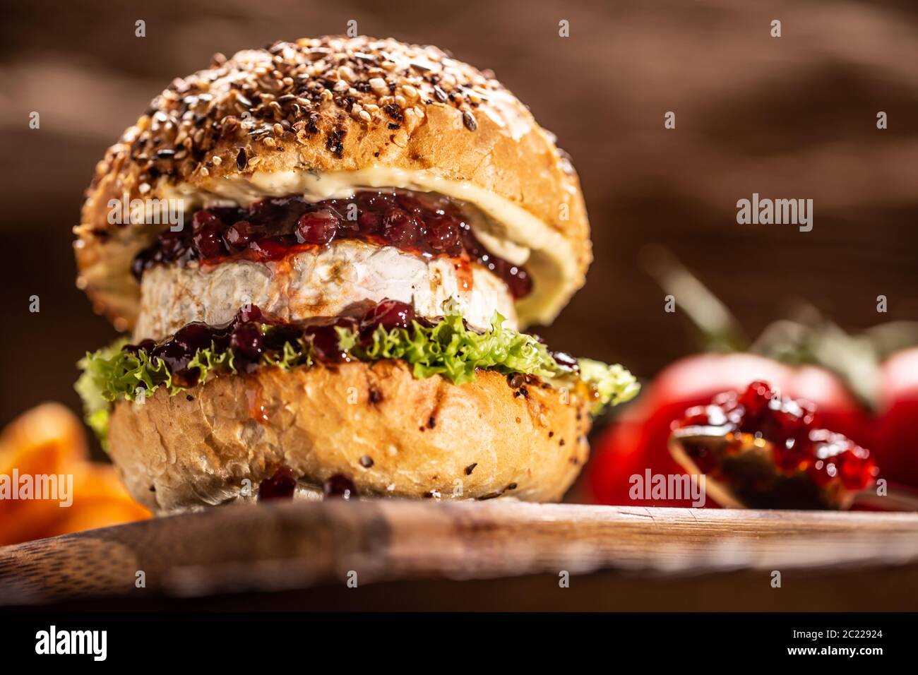 Hamburger végétarien avec sauce camembert et canneberge sur un bois rustique Banque D'Images