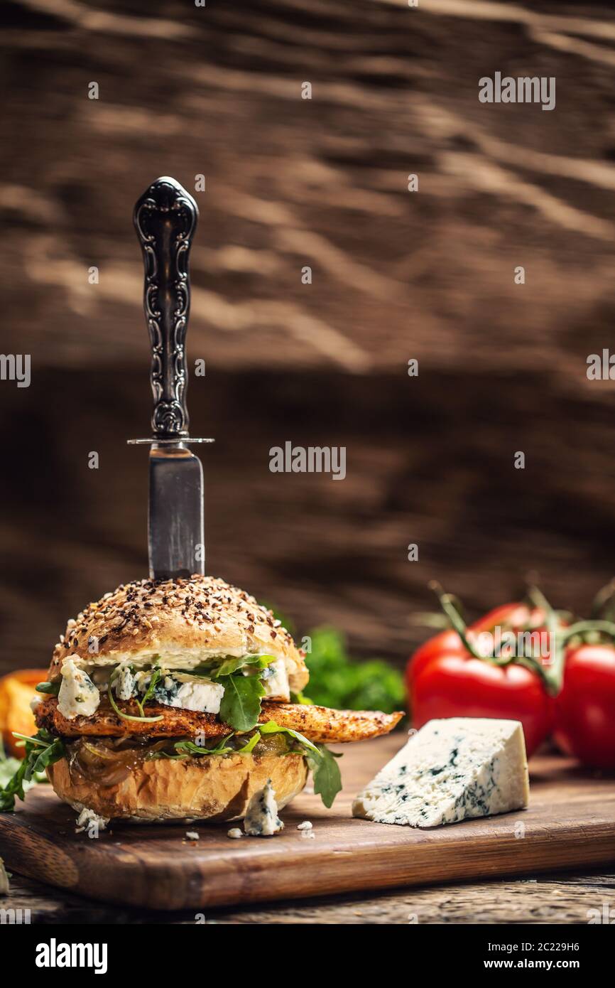 Hamburger de poulet au fromage bleu et à l'arugula dans un pain au sésame sur un bois rustique Banque D'Images