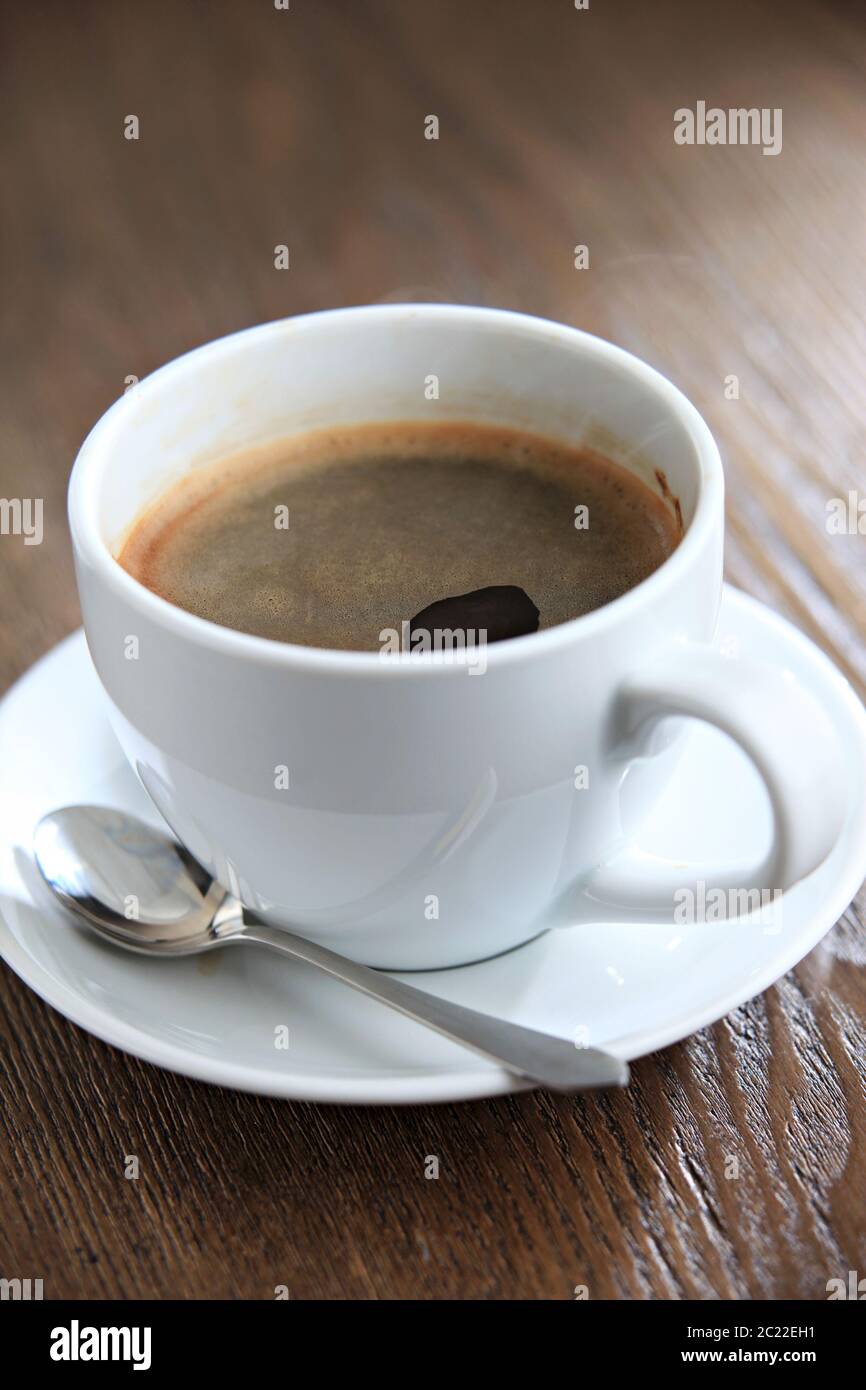 Une tasse de café chaud du matin avec du lait ou de la crème sur une table  en bois avec une douce lumière du soleil Photo Stock - Alamy