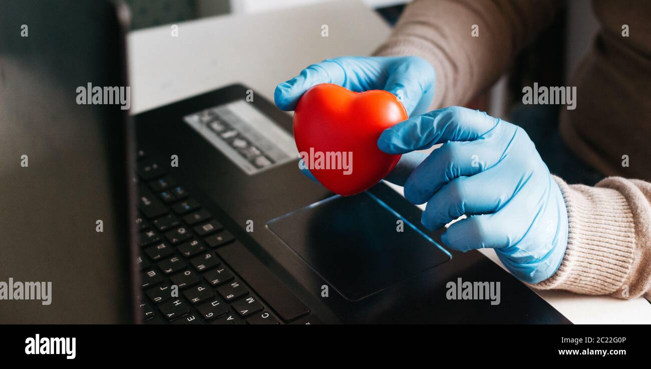 Un homme travaillant à domicile sur un ordinateur portable portant des gants jetables pour la protection. Épidémie de coronavirus. Homme d'affaires en quarantaine. Travail à domicile. Restez à Banque D'Images