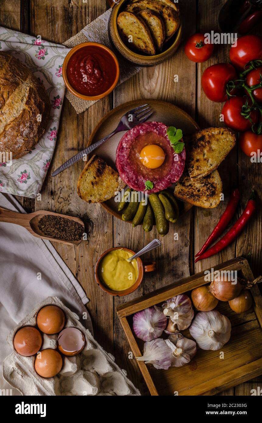 Tartare de boeuf, un plat délicieux plat de protéines avec des épices, de la moutarde, l'oeuf et le pain frit à l'ail Banque D'Images