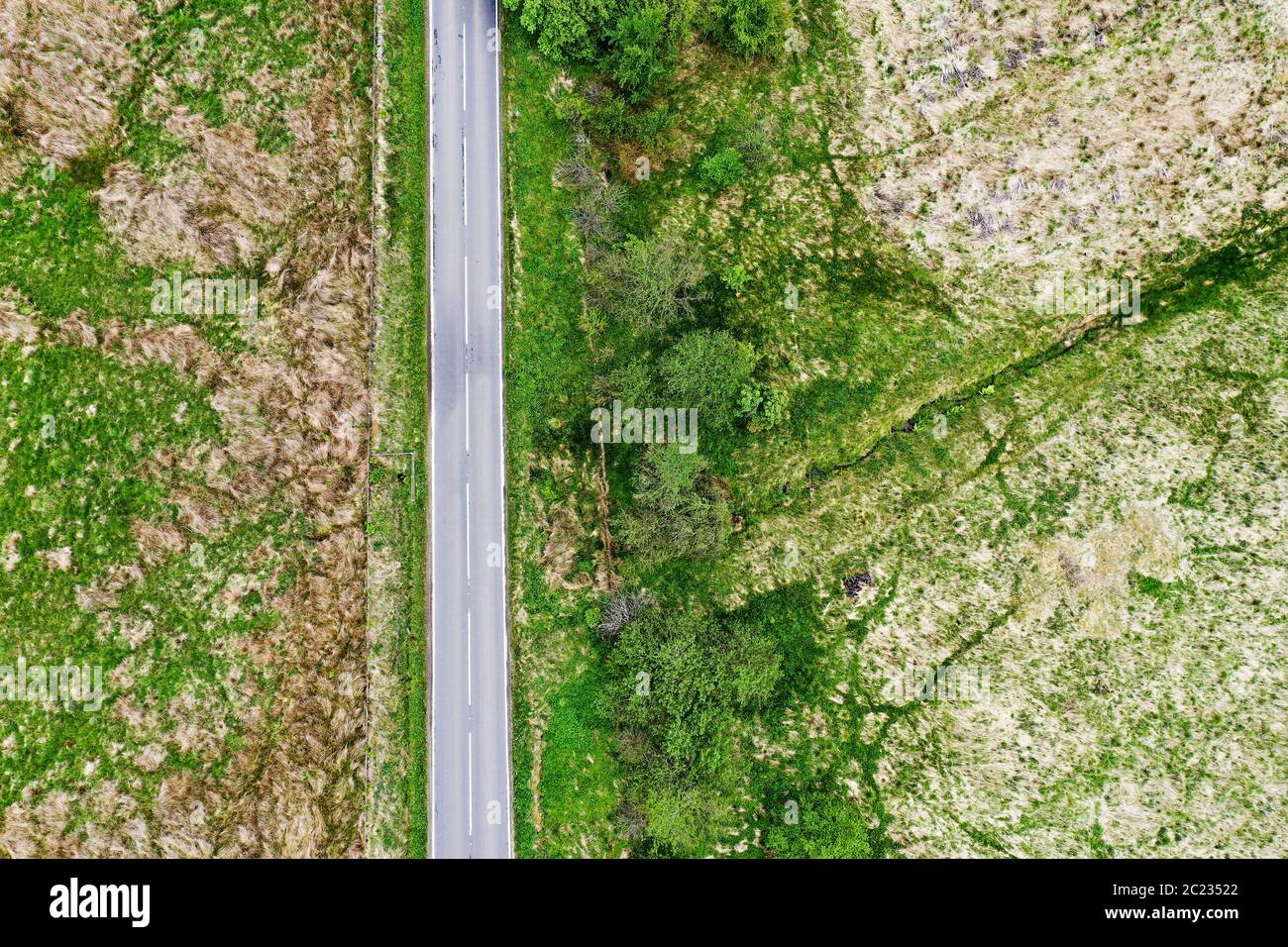 Vue aérienne par drone de la route du tarmac à travers les champs Banque D'Images