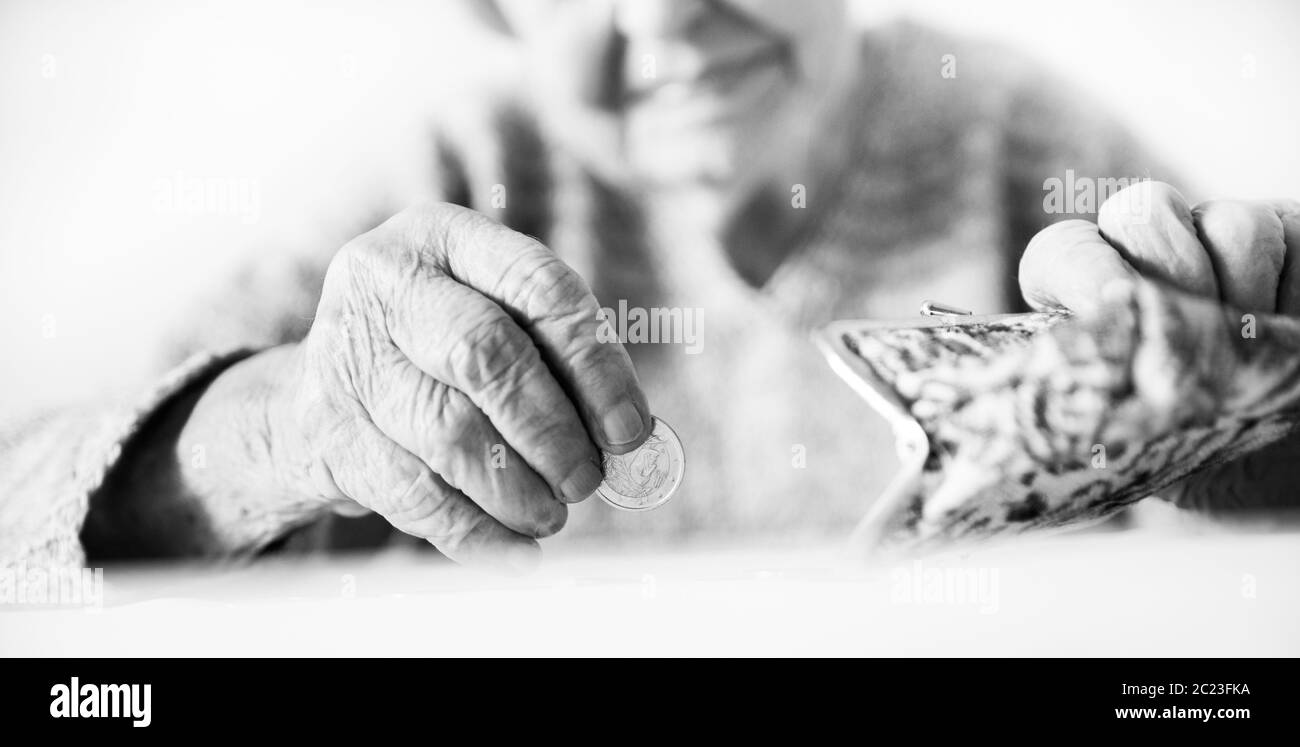 Photo gros plan de personnes âgées 96 ans womans mains restant de comptage de pièces en pension wallet après le paiement des factures. L'insoutenabilité de la tran Banque D'Images