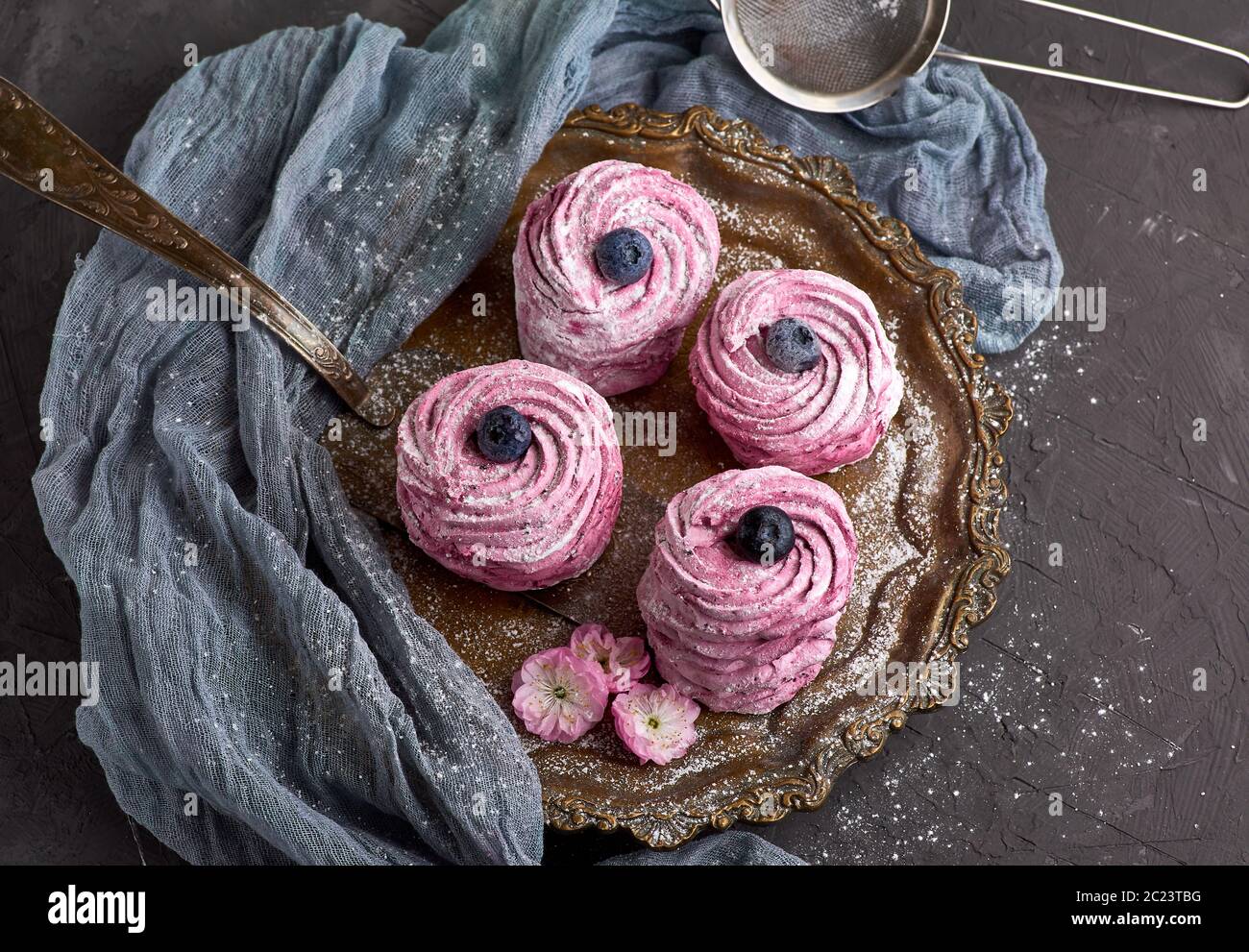 Guimauve rose lumineuse ronde avec des bleuets sur une plaque de fer, vue du dessus Banque D'Images
