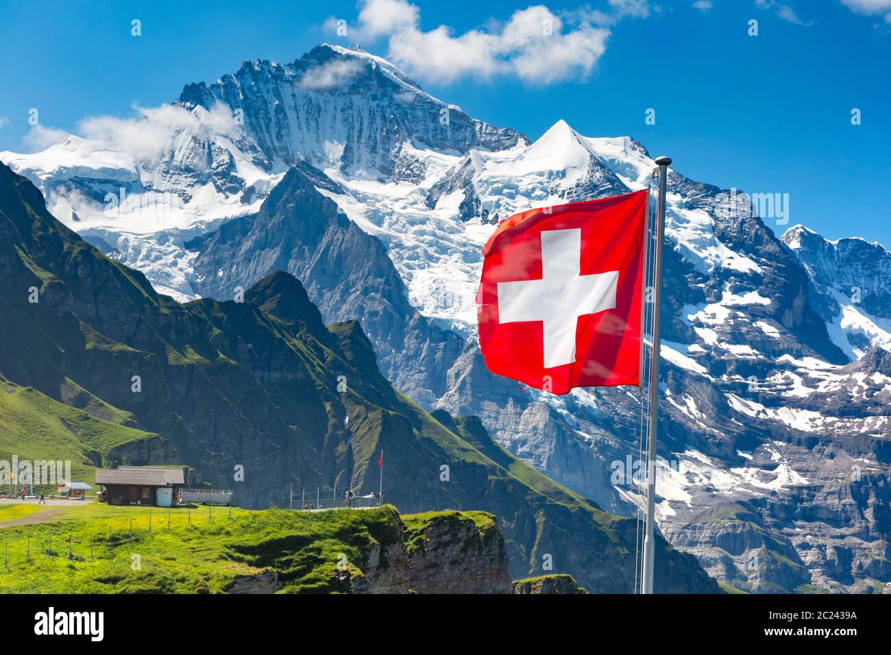 Drapeau suisse un wavingon avec vue Mont Männlichen pic de montagne Jungfrau sur l'arrière-plan, dans l'Oberland bernois Suisse Banque D'Images