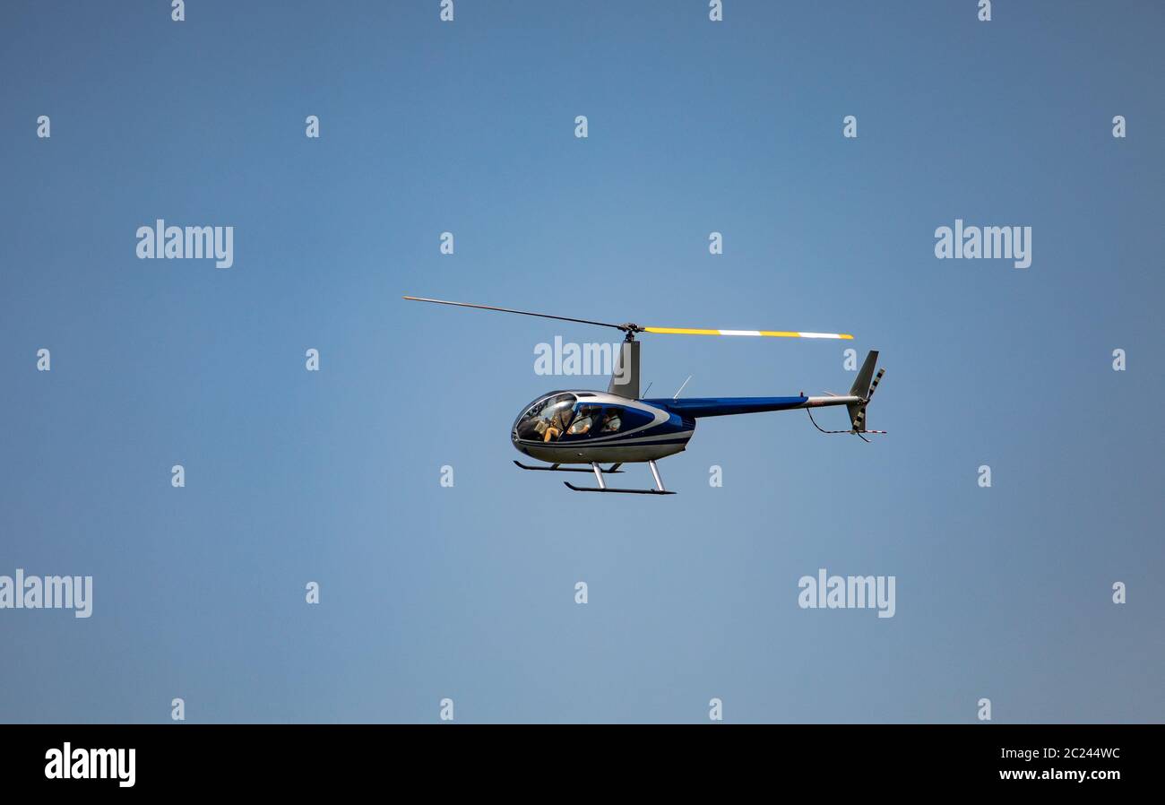 Robinson 44 Raven II en vol sur un ciel bleu clair Banque D'Images