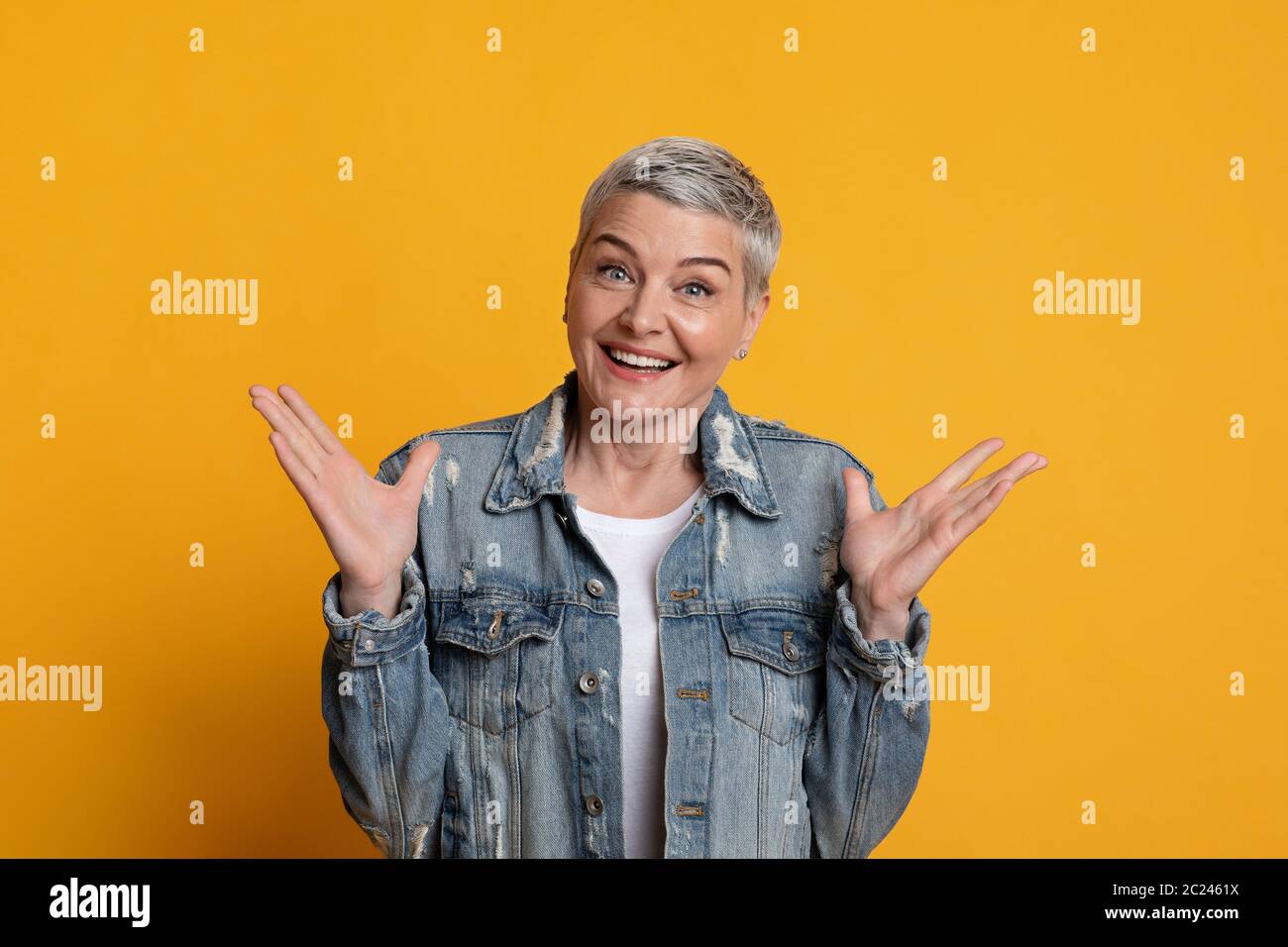 Heureusement surpris. Portrait de gaie femme mature levant les mains avec excitation Banque D'Images