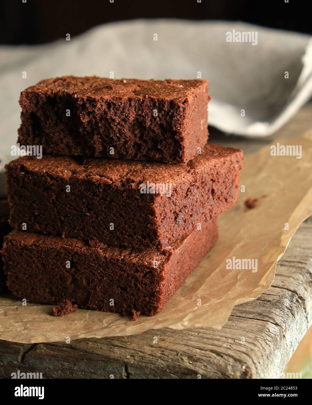 Pile de petits morceaux carrés de chocolat Gâteau Brownie Brown sur le papier parchemin, vue du dessus Banque D'Images