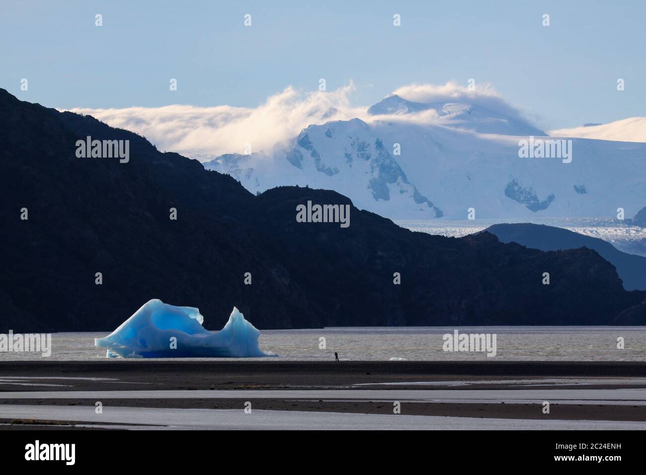 La différence de taille montre peu de photographe devant le grand iceberg Banque D'Images