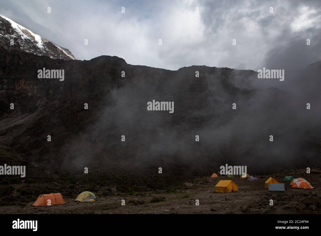 Tentes de grimpeurs sous le mur de roche à Kilimanjaro Banque D'Images